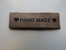 Load image into Gallery viewer, 25 Tan Brown &quot;Hand Made&quot; between 2 Brown Hearts Labels 50mm x 15mm