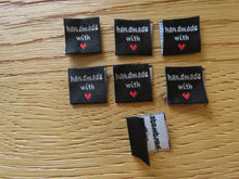 Load image into Gallery viewer, 10 Black Handmade with red heart 2 x 2cm satin flag labels.